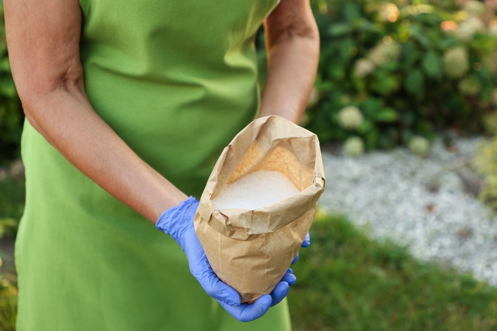 Weißes Pulver auf Gartenweg gestreut